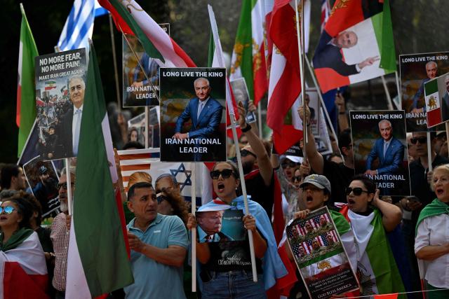 Members of the Iranian community hold placards, wave flags and chant slogans during a rally following US and Israeli attacks on Iran, in Sydney on March 14, 2026. (Photo by Saeed KHAN / AFP)