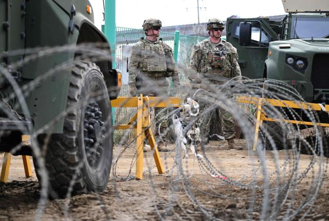 US soldiers stand guard at the entrance to a military training field as they participate in a combined maneuver training with wet gap crossing during the 2026 South Korea-US Freedom Shield military exercise in Yeoncheon on March 14, 2026. (Photo by Jung Yeon-je / AFP)