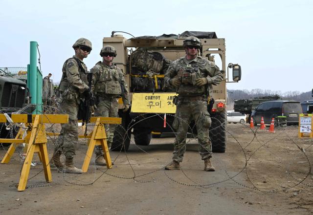 US soldiers cross a river over a floating bridge as they participate in a combined maneuver training with wet gap crossing during the 2026 South Korea-US Freedom Shield military exercise in Yeoncheon on March 14, 2026. (Photo by Jung Yeon-je / AFP)