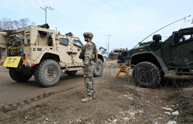 US soldiers cross a river over a floating bridge as they participate in a combined maneuver training with wet gap crossing during the 2026 South Korea-US Freedom Shield military exercise in Yeoncheon on March 14, 2026. (Photo by Jung Yeon-je / AFP)