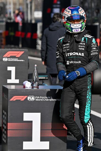 Mercedes' Italian driver Kimi Antonelli celebrates winning the pole position after the qualifying session ahead of the Formula One Chinese Grand Prix at the Shanghai International Circuit in Shanghai on March 14, 2026. (Photo by HECTOR RETAMAL / AFP)