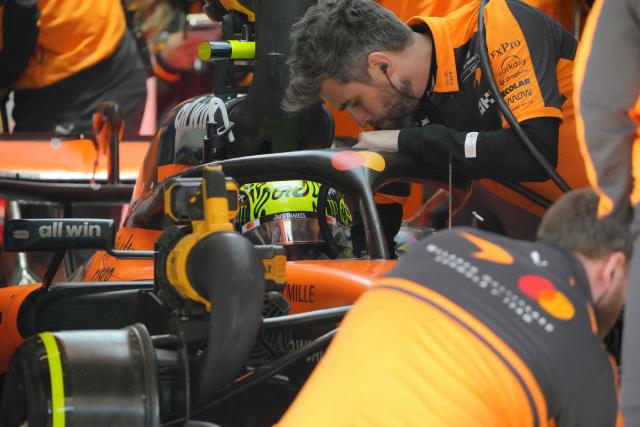 McLaren's British driver Lando Norris sits in his car in the pits as mechanics work around him during the qualifying session ahead of the Formula One Chinese Grand Prix at the Shanghai International Circuit in Shanghai on March 14, 2026. (Photo by Andy Wong / POOL / AFP)