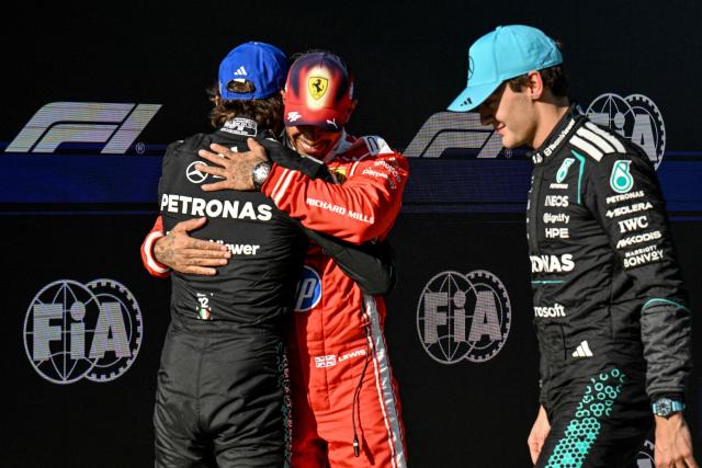 Mercedes' Italian driver Kimi Antonelli (L) celebrates winning the pole position with third-placed Ferrari's British driver Lewis Hamilton (C) as second-placed Mercedes' British driver George Russell looks on after the qualifying session ahead of the Formula One Chinese Grand Prix at the Shanghai International Circuit in Shanghai on March 14, 2026. (Photo by Hector RETAMAL / AFP)