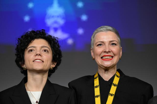 Belarusian street protest leader Maria Kolesnikova (R) reacts next to her sister Tatiana Khomich after having been awarded with the 2022 International Charlemagne Prize of Aachen (Karlspreis) during a ceremony at the Coronation Hall of the Town Hall in Aachen, western Germany on March 14, 2026. Kolesnikova was belatedly awarded with the 2022 International Charlemagne Prize of Aachen due to her political imprisonment in Belarus. She was released on December 13, 2025 along with 122 other prisoners after more than five years in prison for opposing Belarus's President Lukashenko. (Photo by INA FASSBENDER / AFP)