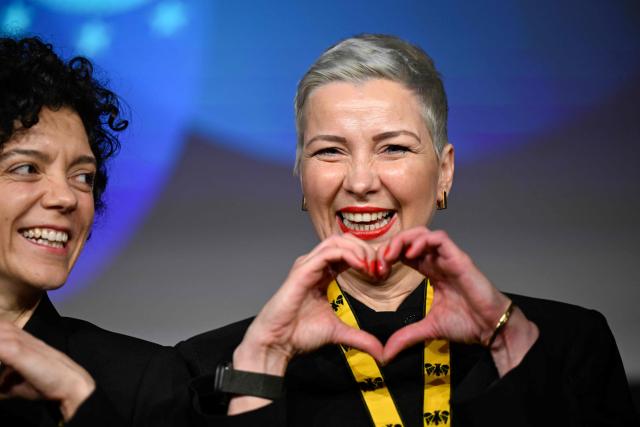 Belarusian street protest leader Maria Kolesnikova (R) gestures next to her sister Tatiana Khomich after having been awarded with the 2022 International Charlemagne Prize of Aachen (Karlspreis) during a ceremony at the Coronation Hall of the Town Hall in Aachen, western Germany on March 14, 2026. Kolesnikova was belatedly awarded with the 2022 International Charlemagne Prize of Aachen due to her political imprisonment in Belarus. She was released on December 13, 2025 along with 122 other prisoners after more than five years in prison for opposing Belarus's President Lukashenko. (Photo by INA FASSBENDER / AFP)