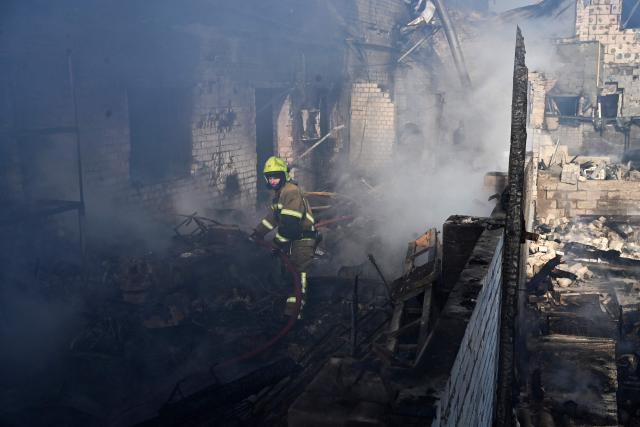 A firefighter extinguishes a fire at a site of a strike in the town of Brovary, near Kyiv, following a Russian missile and drone attack, on March 14, 2026, amid the Russian invasion of Ukraine. Russian drone and missile strikes near Ukraine's capital killed two people and wounded four, the regional military administration said on March 14. "Sadly, two people have been killed in the Brovary Raion. Four more have been injured," said Mykola Kalashnyk, the head of Kyiv region's military administration, in a post on Telegram. (Photo by Genya SAVILOV / AFP)