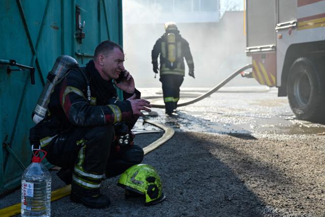 Firefighters work at a site of a strike in the town of Brovary, near Kyiv, following a Russian missile and drone attack, on March 14, 2026, amid the Russian invasion of Ukraine. Russian drone and missile strikes near Ukraine's capital killed two people and wounded four, the regional military administration said on March 14. "Sadly, two people have been killed in the Brovary Raion. Four more have been injured," said Mykola Kalashnyk, the head of Kyiv region's military administration, in a post on Telegram. (Photo by Genya SAVILOV / AFP)