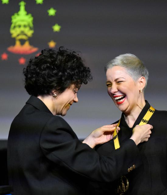 Belarusian street protest leader Maria Kolesnikova (R) reacts as her sister Tatiana Khomich awards her with the 2022 International Charlemagne Prize of Aachen (Karlspreis) during a ceremony at the Coronation Hall of the Town Hall in Aachen, western Germany on March 14, 2026. Kolesnikova was belatedly awarded with the 2022 International Charlemagne Prize of Aachen due to her political imprisonment in Belarus. She was released on December 13, 2025 along with 122 other prisoners after more than five years in prison for opposing Belarus's President Lukashenko. (Photo by INA FASSBENDER / AFP)