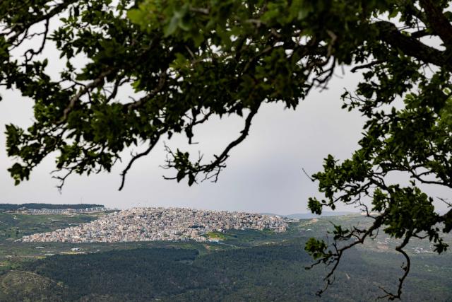 An Arab-Israeli village and new housing are seen on a hilltop from the opposite Mount Tabor, northern-central Israel on March 14, 2026. Galilee is a mountainous, fertile region in northern Israel bordered by the Jordan Valley and the Mediterranean. (Photo by Odd ANDERSEN / AFP)
