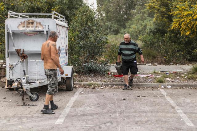 Residents check the damage to property the day after a missile was intersected on the outskirts of Tel Aviv on March 14, 2026. On February 28, Israel and the United States launched strikes on Iran, killing its supreme leader and triggering a war that spread across the Middle East. (Photo by Ilia YEFIMOVICH / AFP) / 