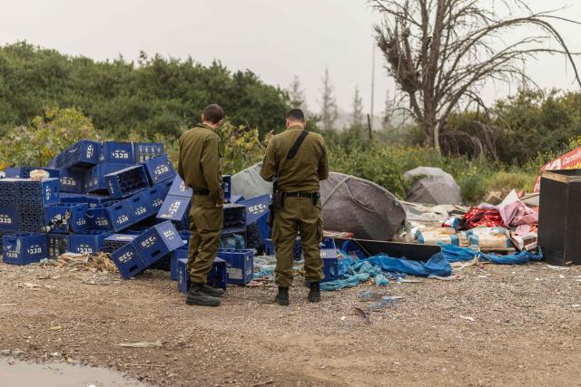 Home front Israeli soldiers check the damage the day after a strike on the outskirts of Tel Aviv on March 14, 2026. On February 28, Israel and the United States launched strikes on Iran, killing its supreme leader and triggering a war that spread across the Middle East. (Photo by Ilia YEFIMOVICH / AFP) / 