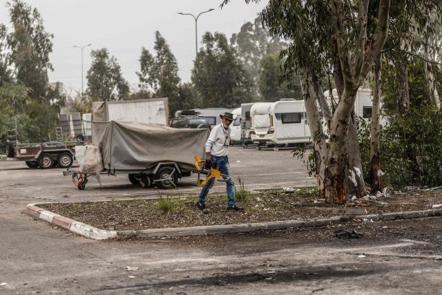 Residents check the damage to property the day after a missile was intersected on the outskirts of Tel Aviv on March 14, 2026. On February 28, Israel and the United States launched strikes on Iran, killing its supreme leader and triggering a war that spread across the Middle East. (Photo by Ilia YEFIMOVICH / AFP) / 