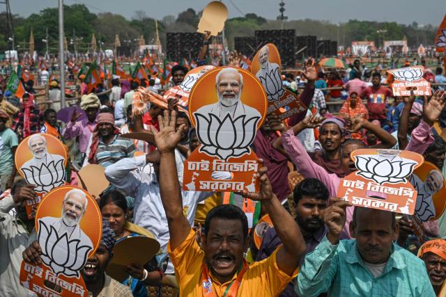 Bharatiya Janata Party (BJP) supporters holding posters of India's Prime Minister Narendra Modi attend a mass rally in Kolkata on March 14, 2026. (Photo by Dibyangshu SARKAR / AFP)