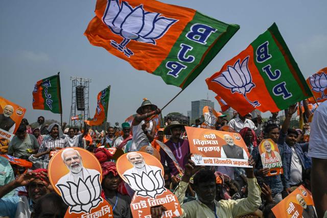 Bharatiya Janata Party (BJP) supporters holding posters of India's Prime Minister Narendra Modi attend a mass rally in Kolkata on March 14, 2026. (Photo by Dibyangshu SARKAR / AFP)