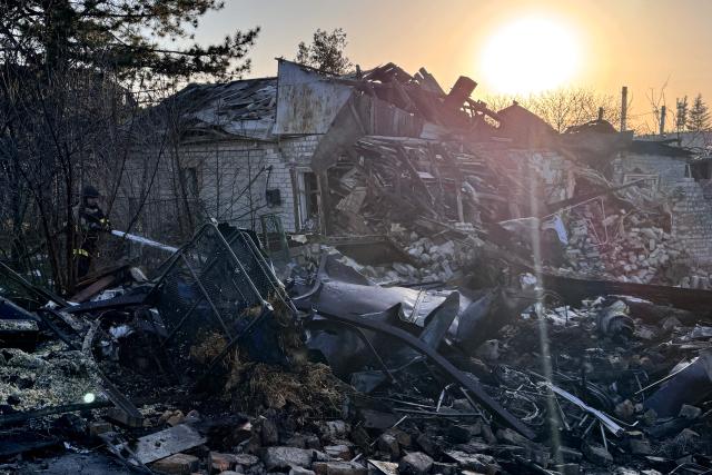 A Ukrainian rescuer works to extinguish a fire at the site of an air attack in Zaporizhzhia on March 14, 2026, amid the Russian invasion of Ukraine. (Photo by Darya NAZAROVA / AFP)