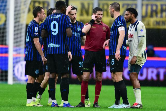 Italian referee Manganiello awaits a VAR review decision during the Italian Serie A football match between Inter Milan and Atalanta at the San Siro stadium in Milan, northern Italy, on March 14, 2026. (Photo by MARCO BERTORELLO / AFP)