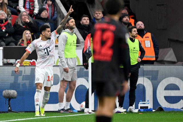 Bayern Munich's Colombian forward #14 Luis Diaz celebrates scoring the 1-1 goal with his teammates during the German first division Bundesliga football match between Bayer 04 Leverkusen and FC Bayern Munich in Leverkusen, western Germany on March 14, 2026. (Photo by INA FASSBENDER / AFP) / DFL REGULATIONS PROHIBIT ANY USE OF PHOTOGRAPHS AS IMAGE SEQUENCES AND/OR QUASI-VIDEO
