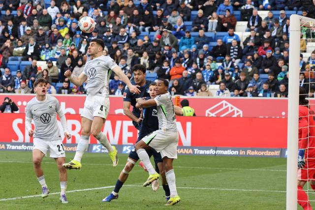 Wolfsburg's Greek defender #04 Konstantinos Koulierakis (2nd L) jumps for a header during the German first division Bundesliga football match between TSG 1899 Hoffenheim and VfL Wolfsburg in Sinsheim, southwestern Germany on March 14, 2026. (Photo by Daniel ROLAND / AFP) / DFL REGULATIONS PROHIBIT ANY USE OF PHOTOGRAPHS AS IMAGE SEQUENCES AND/OR QUASI-VIDEO