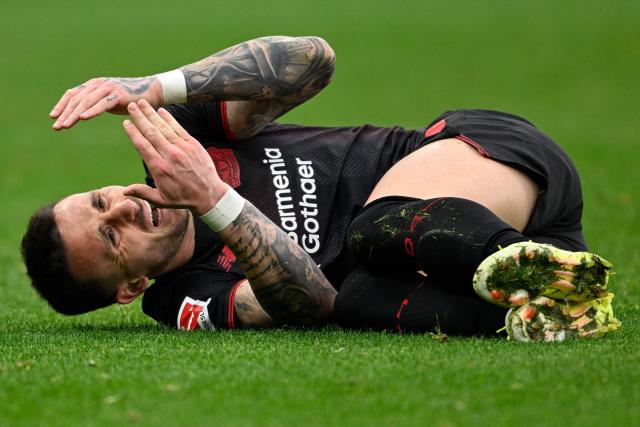 Bayer Leverkusen's Spanish midfielder #24 Aleix Garcia reacts after sustaining an injury during the German first division Bundesliga football match between Bayer 04 Leverkusen and FC Bayern Munich in Leverkusen, western Germany on March 14, 2026. (Photo by INA FASSBENDER / AFP) / DFL REGULATIONS PROHIBIT ANY USE OF PHOTOGRAPHS AS IMAGE SEQUENCES AND/OR QUASI-VIDEO