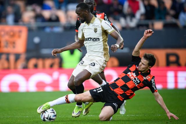 Lens' Senegalese forward #19 Abdallah Sima (L) fights for the ball with Lorient's French midfielder #11 Theo Le Bris during the French L1 football match between FC Lorient and RC Lens at the Stade du Moustoir in Lorient, western France, on March 14, 2026. (Photo by Loic VENANCE / AFP)