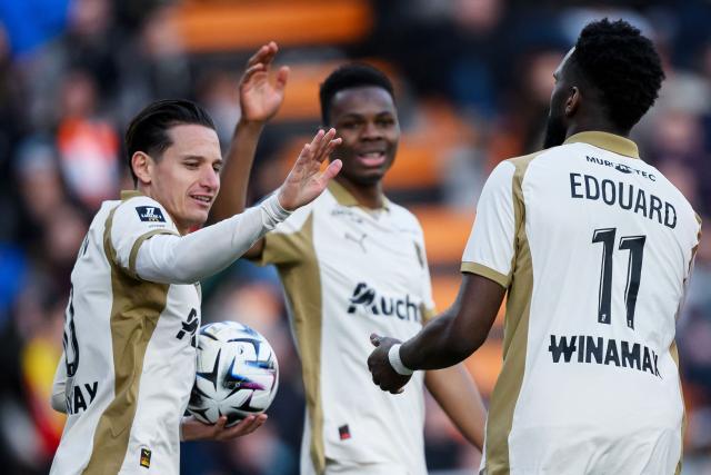 Lens' French forward #11 Odsonne Edouard (R) celebrates with teammates after scoring his team's first goal during the French L1 football match between FC Lorient and RC Lens at the Stade du Moustoir in Lorient, western France, on March 14, 2026. (Photo by Loic VENANCE / AFP)