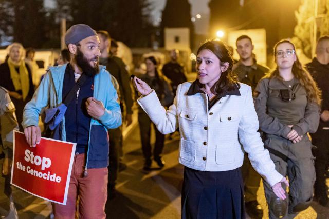 Hadar Muchtar (R), Israeli social media influencer and independent politician engages a protestor holding a banner during an anti-war protest in Haifa on March 14, 2026. On February 28, Israel and the United States launched strikes on Iran, killing its supreme leader and triggering a war that spread across the Middle East. (Photo by Odd ANDERSEN / AFP)