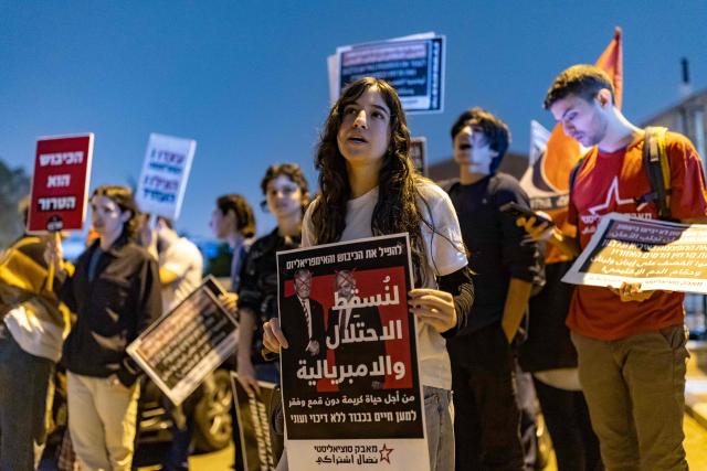 Protestors hold banners during an anti-war protest in Haifa on March 14, 2026. On February 28, Israel and the United States launched strikes on Iran, killing its supreme leader and triggering a war that spread across the Middle East. (Photo by Odd ANDERSEN / AFP) / 