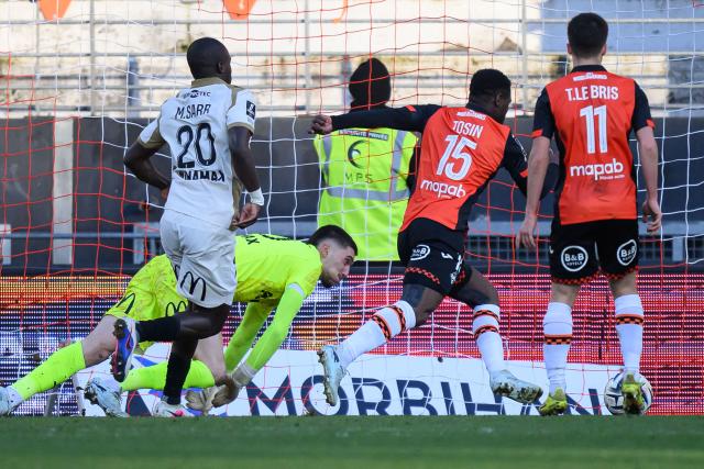 Lorient's Senegalese forward #15 Aiyegun Tosin (C) scores during the French L1 football match between FC Lorient and RC Lens at Yves-Allainmat stadium in Lorient, western France on March 14, 2026. (Photo by Loic VENANCE / AFP)
