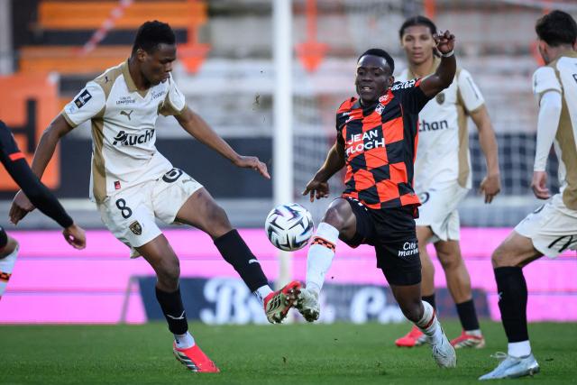 Lorient's Cameroonian midfielder #62 Arthur Avom Ebong (R) fights for the ball with Lens' Malian midfielder #08 Mamadou Sangare during the French L1 football match between FC Lorient and RC Lens at Yves-Allainmat stadium in Lorient, western France on March 14, 2026. (Photo by Loic VENANCE / AFP)