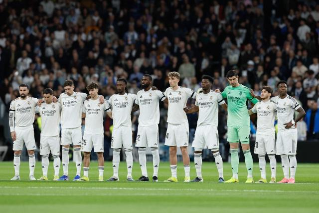 Real Madrid players observe a moment of silence in memory of Vicente Paniagua, a former Real Madrid basketball player who passed away last Saturday, before the Spanish league football match between Real Madrid CF and Elche CF at the Santiago Bernabeu Stadium in Madrid on March 14, 2026. (Photo by Oscar DEL POZO / AFP)