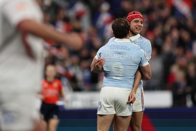 France's wing Louis Bielle-Biarrey (R) celebrates with France's scrum-half Antoine Dupont (C) after scoring France's first try during the Six Nations international rugby union match between France and England at the Stade de France, in Saint-Denis, north of Paris, on March 14, 2026. (Photo by FRANCK FIFE / AFP)