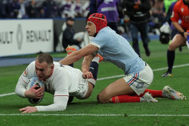 England's wing Tom Roebuck (L) dives over the line to score England's first try during the Six Nations international rugby union match between France and England at the Stade de France, in Saint-Denis, north of Paris, on March 14, 2026. (Photo by Thomas SAMSON / AFP)