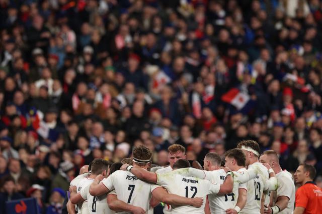 England's players form a huddle during of the Six Nations international rugby union match between France and England at the Stade de France, in Saint-Denis, north of Paris, on March 14, 2026. (Photo by FRANCK FIFE / AFP)