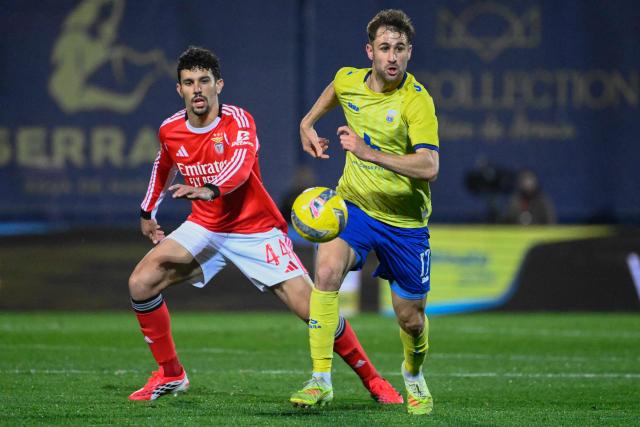 SL Benfica's Portuguese defender #44 Tomas Araujo (L) vies for the ball with FC Arouca's Spanish forward #17 Ivan Barbero during the Portuguese League football match between FC Arouca and SL Benfica at Municipal de Arouca stadium in Aveiro on March 14, 2026. (Photo by Miguel RIOPA / AFP)