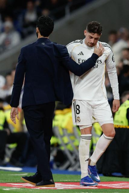 Real Madrid's Uruguayan midfielder #08 Federico Valverde embraces Real Madrid's Spanish coach Alvaro Arbeloa as he leaves the pitch after being substituted during the Spanish league football match between Real Madrid CF and Elche CF at the Santiago Bernabeu Stadium in Madrid on March 14, 2026. (Photo by Oscar DEL POZO / AFP)