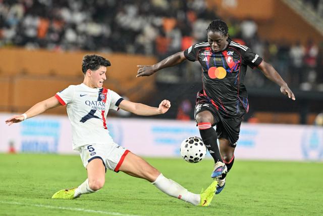 OL-Lyonnes' Tabitha Chawinga fights for the ball with Paris' Elisa De Almeida during the France LFFP Cup football final match between Paris Saint-Germain (PSG) and OL Lyonnes (Lyon) at the Felix Houphouet-Boigny stadium in Abidjan on March 14, 2026. OL Lyonnes won the inaugural Women’s League Cup, comfortably beating Paris SG 1-0 thanks to a goal from their Haitian striker in Abidjan, Ivory Coast, where the final had been relocated. (Photo by Issouf SANOGO / AFP)