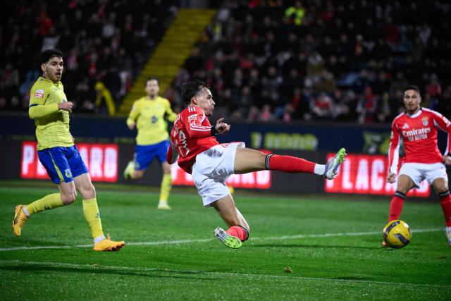 SL Benfica's Bosnian defender #17 Amar Dedic (C) shoots at goal during the Portuguese League football match between FC Arouca and SL Benfica at Municipal de Arouca stadium in Aveiro on March 14, 2026. (Photo by Miguel RIOPA / AFP)