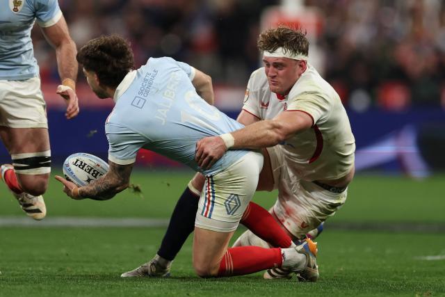 England's Alex Coles (R) tackles France's fly-half Matthieu Jalibert (L) during of the Six Nations international rugby union match between France and England at the Stade de France, in Saint-Denis, north of Paris, on March 14, 2026. (Photo by FRANCK FIFE / AFP)