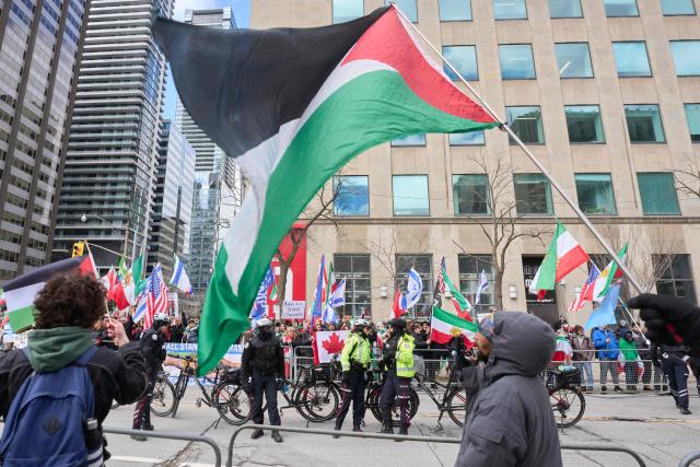 Police form a barrier between Al-Quds day protesters and pro-Israel counter protestors near the US Consulate in Toronto, Ontario, on March 14, 2026. (Photo by Geoff Robins / AFP)