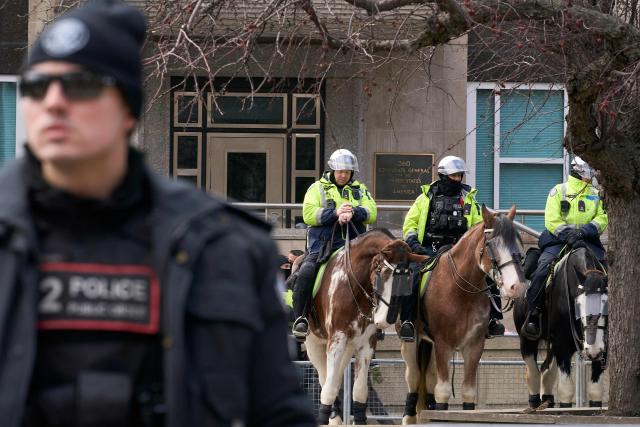 Toronto police officers on horseback stand watch outside the US Consulate during the Al-Quds day protest in Toronto, Ontario, on March 14, 2026. (Photo by Geoff Robins / AFP)