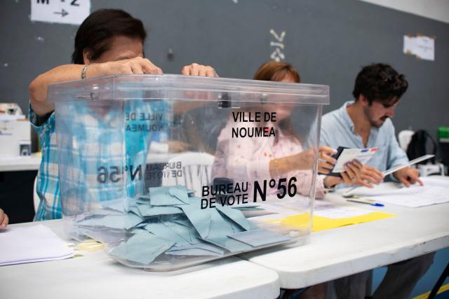 Electoral workers work next to a ballot box during the first round of France's 2026 municipal elections at the Anse Vata Sports Arena in Noumea, in the French overseas collectivity of New Caledonia, on March 15, 2026. (Photo by Delphine MAYEUR / AFP)