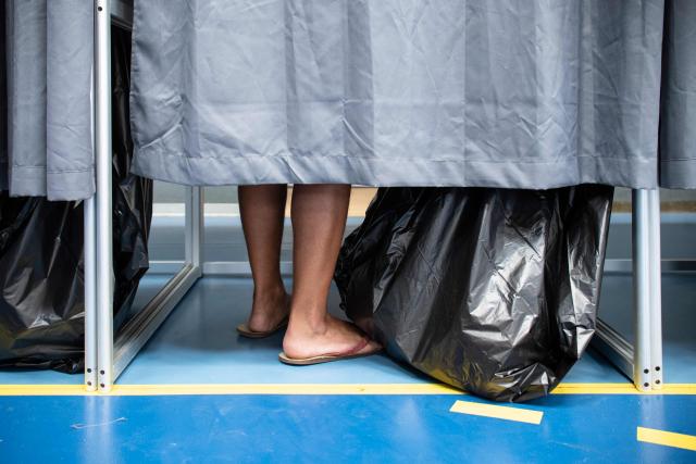 A voters stands in a voting booth during the first round of France's 2026 municipal elections at the Anse Vata Sports Arena in Noumea, in the French overseas collectivity of New Caledonia, on March 15, 2026. (Photo by Delphine MAYEUR / AFP)