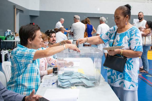 A voter casts her ballot during the first round of France's 2026 municipal elections at the Anse Vata Sports Arena in Noumea, in the French overseas collectivity of New Caledonia, on March 15, 2026. (Photo by Delphine MAYEUR / AFP)
