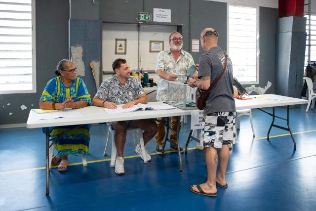 A voter casts his ballot during the first round of France's 2026 municipal elections at the Anse Vata Sports Arena in Noumea, in the French overseas collectivity of New Caledonia, on March 15, 2026. (Photo by Delphine MAYEUR / AFP)