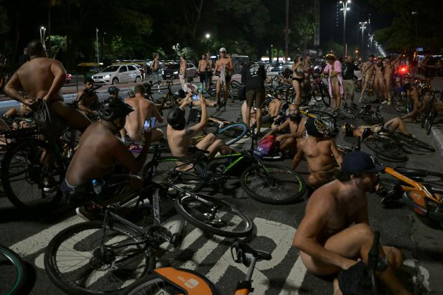 EDITORS NOTE: Graphic content / Naked cyclists demonstrate along Paulista Avenue to demand better conditions on the city’s roads and to raise awareness about cyclist safety and reducing oil dependence, as part of the World Naked Bike Ride international movement in Sao Paulo, Brazil, on March 14, 2026. (Photo by Nelson ALMEIDA / AFP)