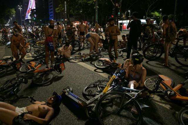 EDITORS NOTE: Graphic content / Naked cyclists demonstrate along Paulista Avenue to demand better conditions on the city’s roads and to raise awareness about cyclist safety and reducing oil dependence, as part of the World Naked Bike Ride international movement in Sao Paulo, Brazil, on March 14, 2026. (Photo by Nelson ALMEIDA / AFP)