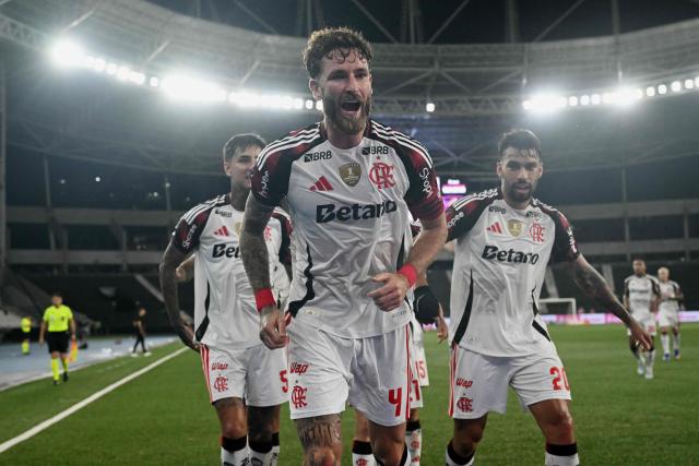 Flamengo's defender #04 Leo Pereira (C) celebrates next to temammates scoring his team's second goal during the Brazilian Championship Serie A football match between Botafogo and Flamengo at the Nilton Santos Stadium in Rio de Janeiro, Brazil on March 14, 2026. (Photo by Mauro PIMENTEL / AFP)
