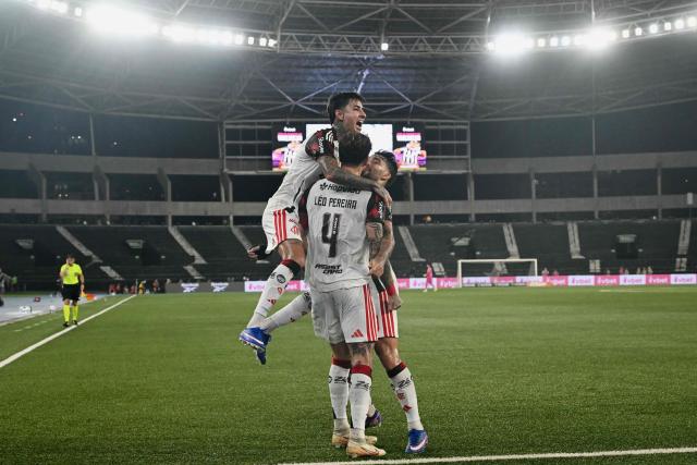 Flamengo's defender #04 Leo Pereira (C) celebrates with temammates scoring his team's second goal during the Brazilian Championship Serie A football match between Botafogo and Flamengo at the Nilton Santos Stadium in Rio de Janeiro, Brazil on March 14, 2026. (Photo by Mauro PIMENTEL / AFP)