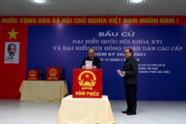 Vietnam's Former National Assembly Chairman Nguyen Sinh Hung (L) casts his vote in Hanoi on March 15, 2026. (Photo by Nhac NGUYEN / AFP)