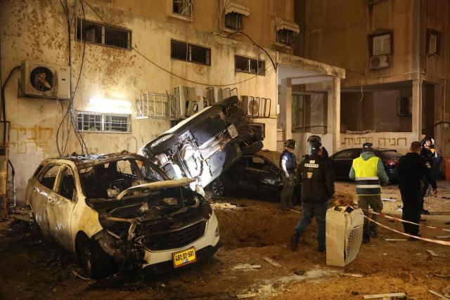 Israeli security checks the damage to cars after a rocket strike in Holon, Israel, on March 15, 2026. (Photo by Jack GUEZ / AFP) / Attention editors: Photo taken with approval from the Ministry of Culture and Islamic Guidance (Ershad) --
AFP covers the war in the Middle East through its extensive regional network, including bureaus in Tehran, Jerusalem, and several neighboring countries. Since the start of the conflict, journalists have been working under increasingly restrictive conditions. Authorities in several countries have limited reporters' movements, photo and live video coverage from sensitive locations. Some governments and armed groups have banned images of missile or drone strikes and other security-related sites. / 